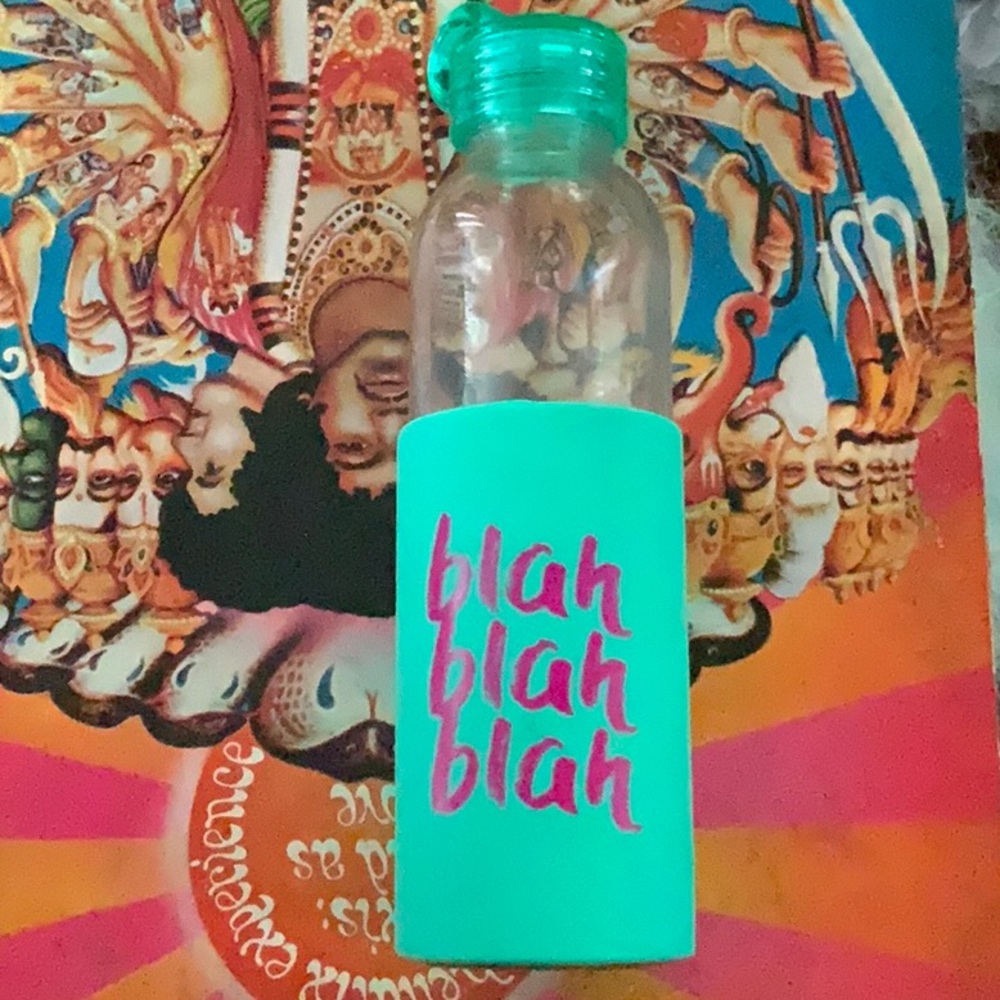 Glass water bottle with teal rubber cover. Green plastic twist lid
